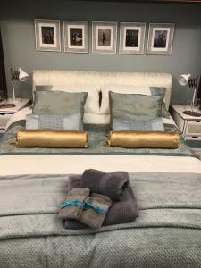 a bed with two pillows and towels on it at The Old Merchants House - The Vettriano Room in Southampton