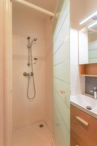 La salle de bains est pourvue d'une douche avec une porte en verre. dans l'établissement Appart cosy avec grand balcon et parking privatif, à Lorient