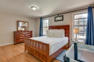 1 dormitorio con cama de madera y ventana en Montgomery Village Townhome with Patio 27 Mi to DC!, en Montgomery Village