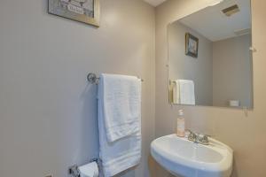 Baño blanco con lavabo y espejo en Montgomery Village Townhome with Patio 27 Mi to DC!, en Montgomery Village