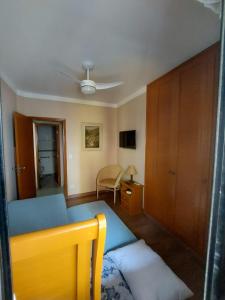 a bedroom with a blue bed and a ceiling fan at Flat Pitangueira com Piscina-Capitânia Varan in Guarujá