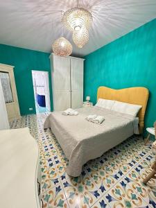 1 dormitorio con cama y pared azul en Villa Vie En Rose en Sorrento