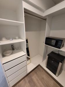 una pequeña cocina con armarios blancos y microondas en Espacio Luxury Apartments “Edificio Boutique B51”, en Lima