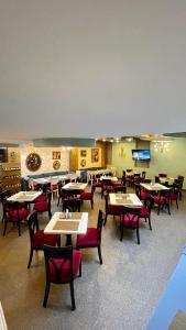 a restaurant with tables and chairs and a tv at Cabecera Country Hotel in Bucaramanga