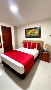 a bedroom with a large bed with a red blanket at Cabecera Country Hotel in Bucaramanga