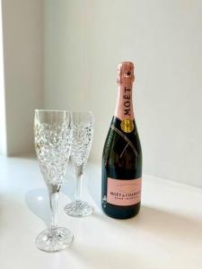 uma garrafa de champanhe e dois copos numa mesa em Sleeps 8 - Bournemouth - Ideal Families & Groups! em Bournemouth