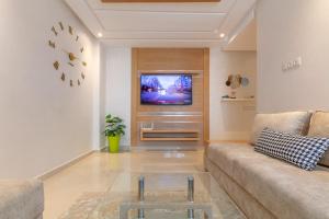 - un salon avec un canapé et une télévision dans l'établissement Charmant appartement près de TGV, à Kenitra