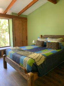 1 dormitorio con cama de madera en una habitación en La Rueda del Chucao en Valdivia