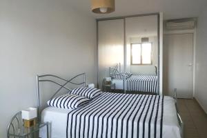 een slaapkamer met 2 bedden en een spiegel bij Le Majestic T2 ~ Clim à 5 min gare St Roch in Montpellier
