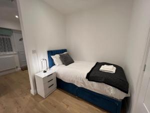 a small bedroom with a bed and a night stand at Luxury, 3 Bed, 2 Bathroom, Free Private Parking in Oxford