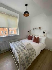 ein Bett in einem Schlafzimmer mit einem großen Fenster in der Unterkunft Flat in Victorian West Kensington Mansion in London