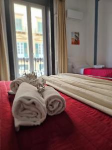 ein Hotelzimmer mit Handtüchern auf einem Bett mit Fenster in der Unterkunft Teatro del Sole Cavour in Palermo