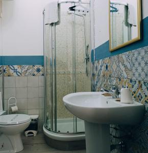 ein Bad mit einem Waschbecken, einer Dusche und einem WC in der Unterkunft Teatro del Sole Cavour in Palermo