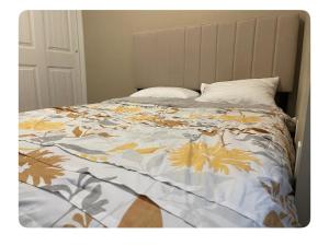 a bed with a blanket with leaves on it at Edmonton in Edmonton