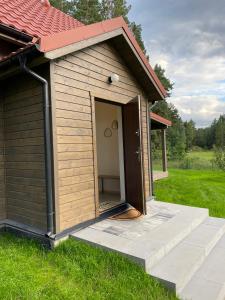 une petite maison pour chiens avec une porte dans l'herbe dans l'établissement Stodoła Drwęck, 