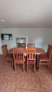 庫蘭尼匹的住宿－Lucerna Hostería，餐桌、两把椅子、一张木桌和椅子