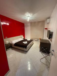 a bedroom with a bed and a red wall at B&B Elia's in Cagliari