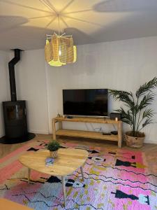 - un salon avec une télévision et une table basse dans l'établissement Rainbow Houses, à Perros-Guirec