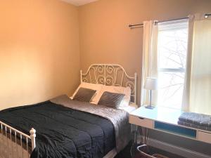 a bedroom with a bed and a desk and a window at Quiet apt only 15 mins away from Midtown Manhattan in Jersey City