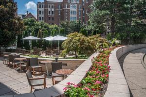 a garden with tables and chairs and flowers at Loews Nashville Hotel at Vanderbilt Plaza in Nashville