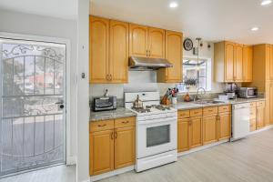 a kitchen with wooden cabinets and white appliances at Buena Park Home with Patio about 9 Mi to Disneyland! in Buena Park