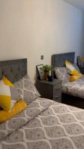 a bedroom with two beds with yellow and white pillows at CityFlat Birmingham City B17 8 in Birmingham