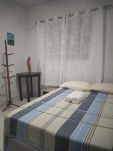 1 dormitorio con 1 cama con manta azul y blanca en Casa de Nylva Beach Pipa, en Pipa