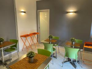 un ristorante con tavoli e sedie verdi in una stanza di B&B Elia's a Cagliari