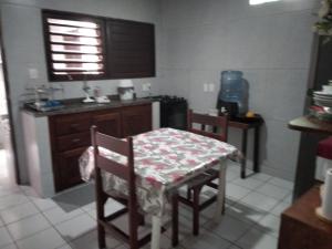 cocina con mesa, 2 sillas y fregadero en Casa de Nylva Beach Pipa, en Pipa