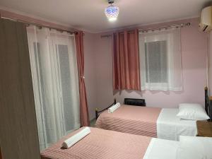 a small bedroom with two beds and a window at FRUIT Echo Villa in Avliótai