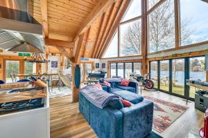 a living room with a blue couch in a house at Riverfront A-Frame Cabin in Troy with Pool and Dock! in Troy