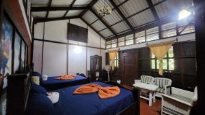1 dormitorio con 2 camas, mesa y sillas en Posada de Don Alonso, en Puerto Barrios