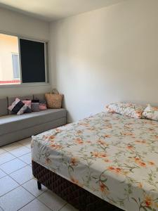 a bedroom with a bed and a couch at Encanto Guarapari in Guarapari