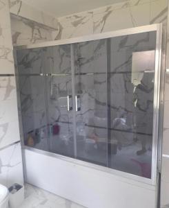 La salle de bains est pourvue d'une porte de douche en verre. dans l'établissement halit ev 2, à Istanbul