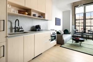 a kitchen with white cabinets and a living room at Switch House Hotel in Philadelphia