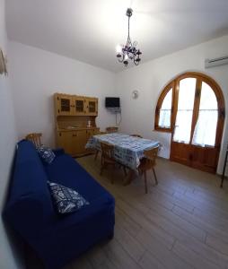 a living room with a table and a blue couch at La Calla Bianca in Torre Dei Corsari +45 photos