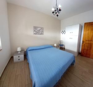 a bedroom with a bed with a blue blanket at La Calla Bianca in Torre Dei Corsari