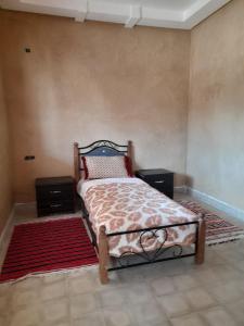 a bedroom with a bed with two night stands and a rug at RISA FAMILY in Taroudant