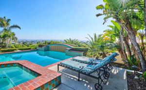 a patio with a pool and a chair next to a swimming pool at 360 Degree Ocean & City Views With Pool, Spa, Close to the Beach! Pets OK in San Diego