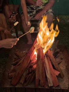 a group of people cooking food on a grill at Bangalôs Flecheiras de Canaã in Flecheiras