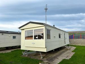 a tiny house is parked in a yard at 519 Family Caravan at Golden Gate Holiday Centre, Sleeps 6 in Abergele