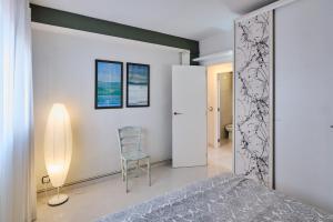 ein Schlafzimmer mit einem Bett und einem Stuhl darin in der Unterkunft Penthouse Inlakesh in Valencia