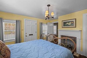 1 dormitorio con cama azul y chimenea en Historic Hartsfield House, en New Bern