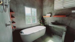 a bathroom with a large white tub and a window at Dins Nature Villa in Elgiriya