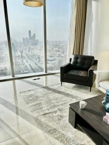 a living room with a black chair and a large window at شقة جميلة مطلة على المركز المالي in Riyadh