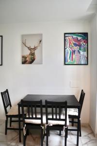 アマドーラにあるAmadora Cozy Houseの黒いダイニングテーブル(椅子2脚付)と絵画