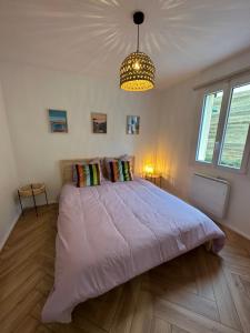 sypialnia z dużym łóżkiem i żyrandolem w obiekcie Rainbow Houses w mieście Perros-Guirec