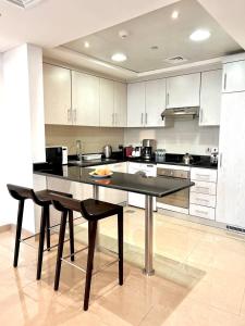 a large kitchen with a large island in the middle at Goatskynest Riyadh skyline view suites in Riyadh
