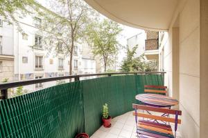 Un balcón con una silla y una valla verde en Charmant Appartement - Portes de Paris, en Charenton-le-Pont