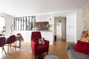 sala de estar con silla roja y mesa en Charmant Appartement - Portes de Paris, en Charenton-le-Pont